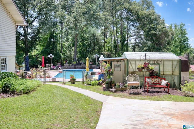 179 Idlewood Cir, Alexandria, AL 36250 - view of yard with a community pool, a patio, view of wooded area, and an outdoor structure