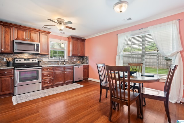 142 Falling Waters Ln, Maylene, AL 35114 - kitchen with stainless steel appliances, dark wood-style flooring, backsplash, ceiling fan, and a sink
