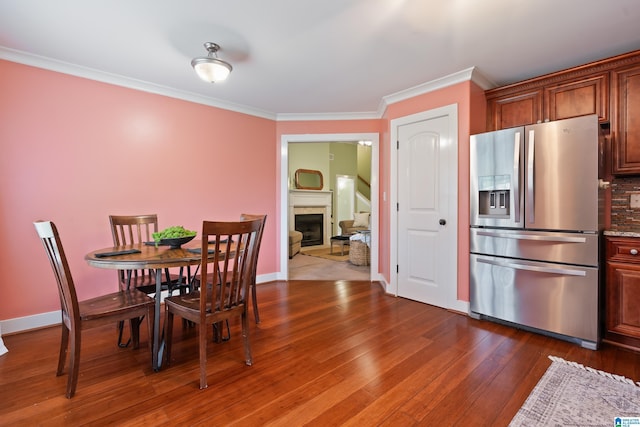 142 Falling Waters Ln, Maylene, AL 35114 - dining area with ornamental molding, a fireplace, dark wood-type flooring, and baseboards