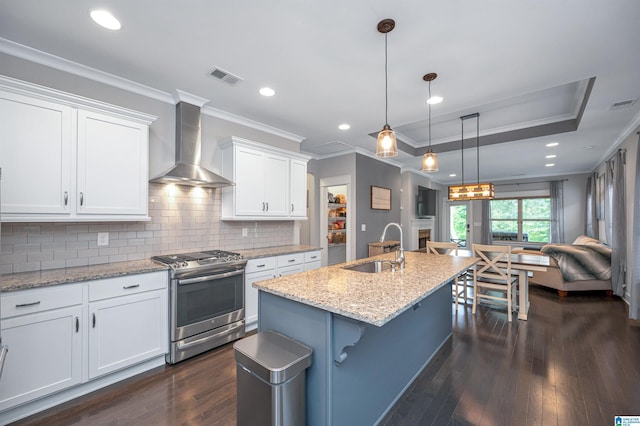 3951 Crest Lndg, Irondale, AL 35210 - kitchen featuring stainless steel gas range oven, wall chimney range hood, a sink, white cabinetry, and dark wood finished floors