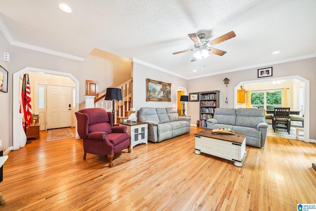 8526 Scenic Ridge Dr, Pinson, AL 35126 - living area with arched walkways, light wood-style flooring, stairs, ceiling fan, and crown molding