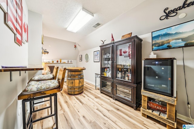 8526 Scenic Ridge Dr, Pinson, AL 35126 - indoor dry bar featuring wood finished floors, lofted ceiling, baseboards, and a textured ceiling