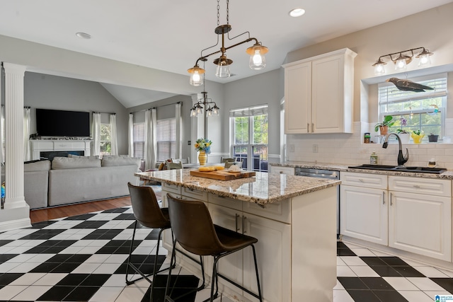1051 Oak Meadows Rd, Birmingham, AL 35242 - kitchen featuring a sink, white cabinets, open floor plan, backsplash, and a center island
