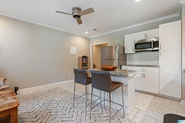 1051 Oak Meadows Rd, Birmingham, AL 35242 - kitchen featuring stainless steel appliances, a kitchen breakfast bar, a kitchen island, a ceiling fan, and tasteful backsplash