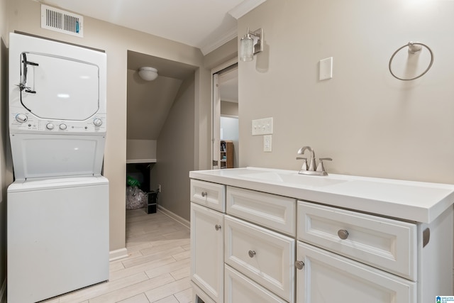1051 Oak Meadows Rd, Birmingham, AL 35242 - bathroom with stacked washer / drying machine, wood finished floors, baseboards, vanity, and lofted ceiling