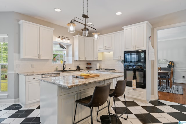 1051 Oak Meadows Rd, Birmingham, AL 35242 - kitchen with black appliances, a sink, white cabinets, a breakfast bar, and a center island