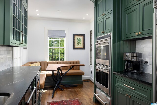 2520 Lanark Rd, Birmingham, AL 35223 - kitchen with green cabinets, double oven, dark wood finished floors, tasteful backsplash, and ornamental molding