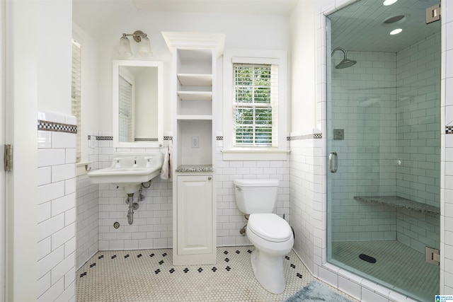 2520 Lanark Rd, Birmingham, AL 35223 - bathroom with tile walls, a stall shower, toilet, tile patterned floors, and a wainscoted wall