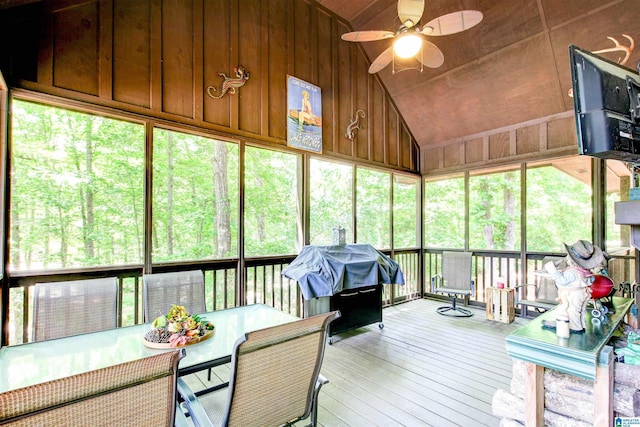 sunroom / solarium featuring a ceiling fan, vaulted ceiling, and outdoor dining space