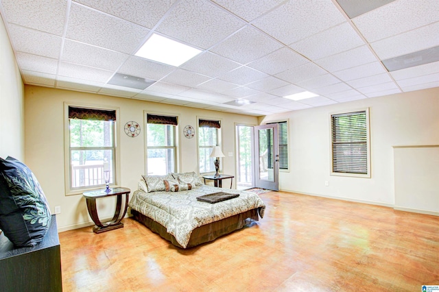 bedroom featuring a paneled ceiling, access to exterior, and baseboards