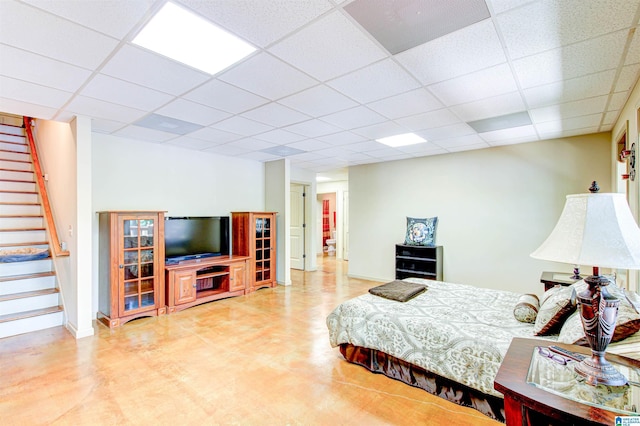 bedroom featuring a paneled ceiling and baseboards