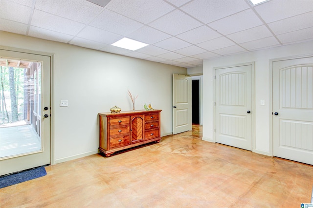 foyer entrance featuring a paneled ceiling and baseboards