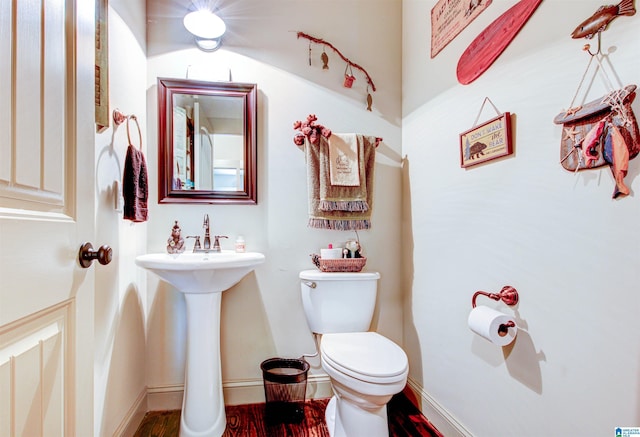 half bathroom featuring toilet and wood finished floors