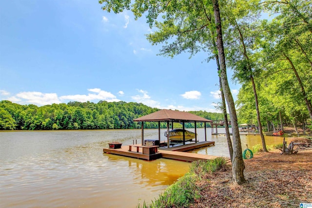 dock area featuring a water view, boat lift, and a forest view