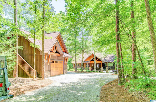 chalet / cabin featuring a shingled roof and a garage
