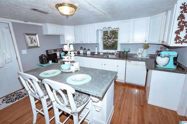 1619 Websters Chapel Rd, Wellington, AL 36279 - kitchen with white dishwasher, a sink, dark countertops, white cabinetry, and a textured ceiling