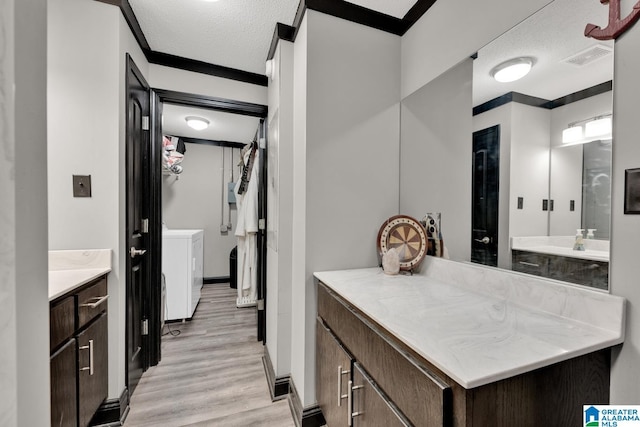 4150 County Highway 13, Locust Fork, AL 35097 - bathroom featuring separate washer and dryer, wood finished floors, vanity, a textured ceiling, and baseboards