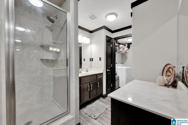 4150 County Highway 13, Locust Fork, AL 35097 - bathroom with a stall shower, washer and clothes dryer, vanity, wood finished floors, and a textured ceiling