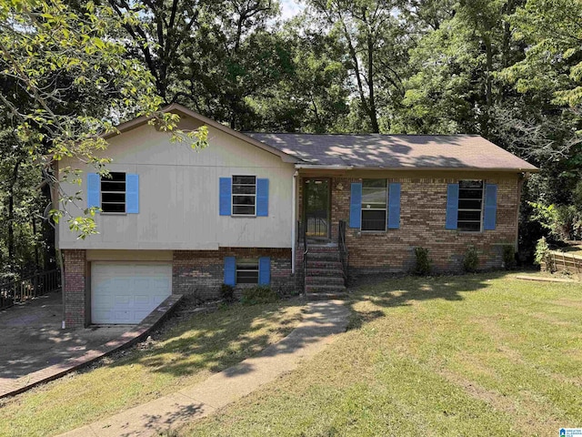 tri-level home featuring a garage, brick siding, driveway, and a front yard