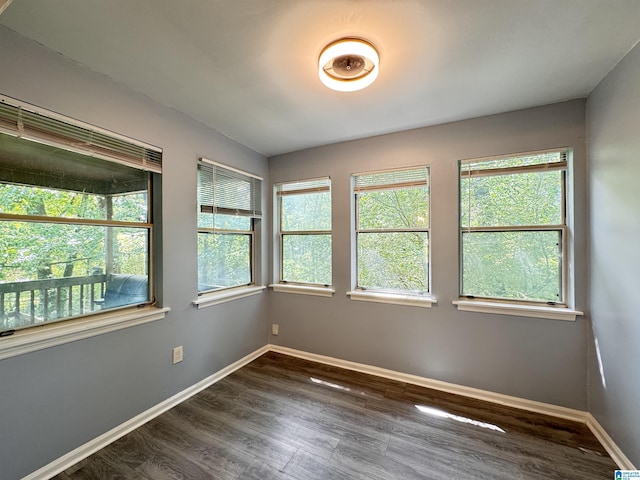 spare room with dark wood-style floors and baseboards