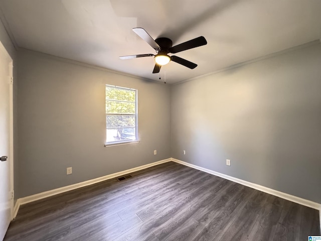 spare room with ornamental molding, ceiling fan, dark wood-type flooring, and baseboards