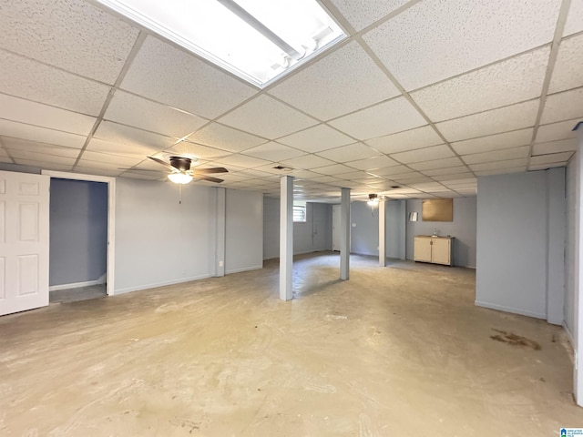 finished basement featuring a drop ceiling, baseboards, and a sink
