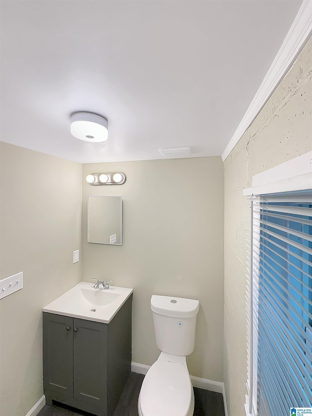 half bath with baseboards, toilet, and vanity