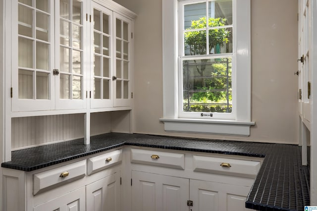 1479 Milner Cres S, Birmingham, AL 35205 - kitchen with dark countertops, white cabinetry, and glass insert cabinets