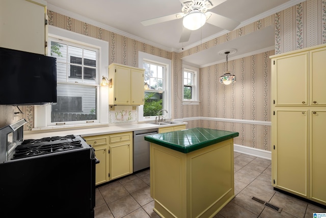 1479 Milner Cres S, Birmingham, AL 35205 - kitchen with cream cabinets, black range with gas stovetop, wallpapered walls, stainless steel dishwasher, and a sink