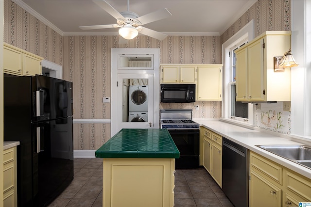 1479 Milner Cres S, Birmingham, AL 35205 - kitchen with black appliances, stacked washer / drying machine, cream cabinets, wallpapered walls, and crown molding