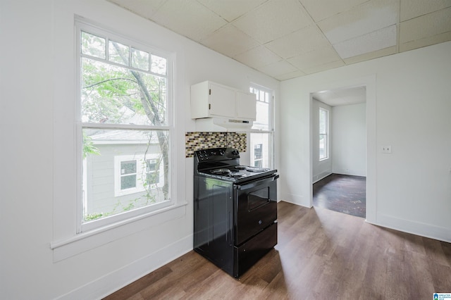 kitchen featuring black range with electric cooktop, wood finished floors, white cabinets, a paneled ceiling, and baseboards