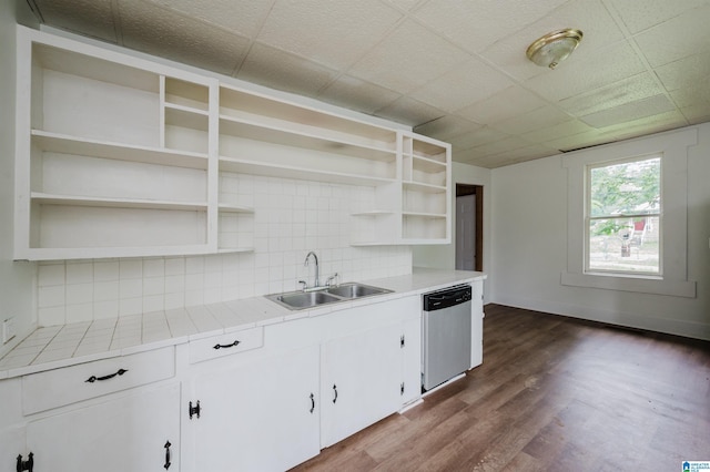 kitchen featuring open shelves, a sink, stainless steel dishwasher, dark wood-type flooring, and decorative backsplash
