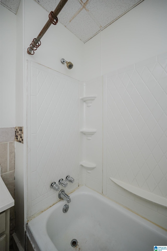 bathroom with shower / washtub combination and a drop ceiling
