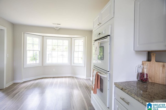 105 Mountain View Ln, Springville, AL 35146 - kitchen with light wood-style flooring, double oven, white cabinets, and baseboards