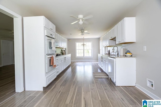 105 Mountain View Ln, Springville, AL 35146 - kitchen with dishwasher, ceiling fan, light wood-style floors, baseboards, and white cabinetry