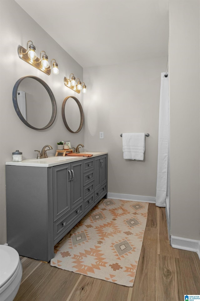 105 Mountain View Ln, Springville, AL 35146 - bathroom with wood finished floors, double vanity, toilet, baseboards, and a shower with shower curtain