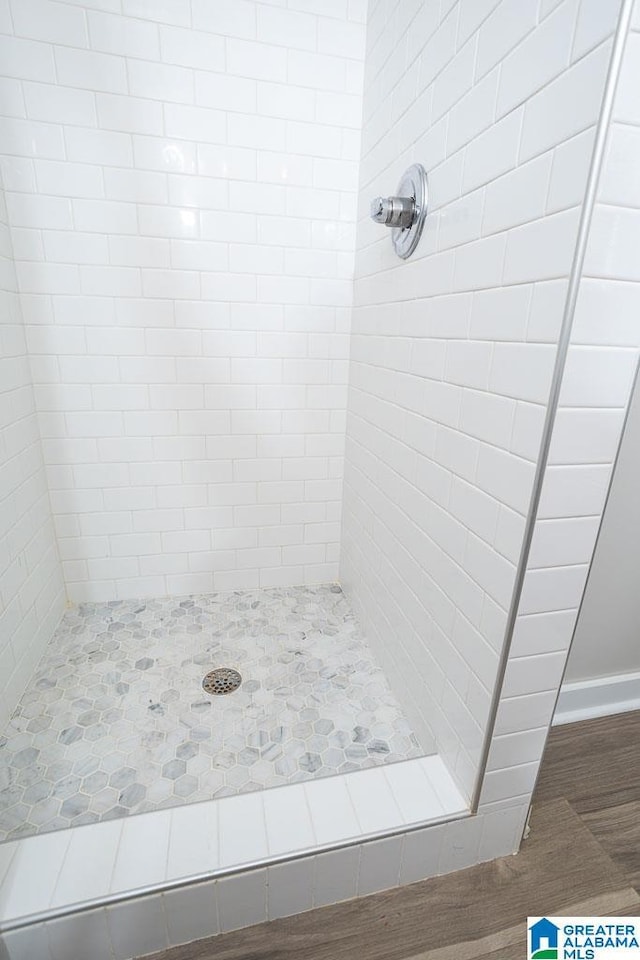105 Mountain View Ln, Springville, AL 35146 - bathroom with a tile shower, wood finished floors, and baseboards