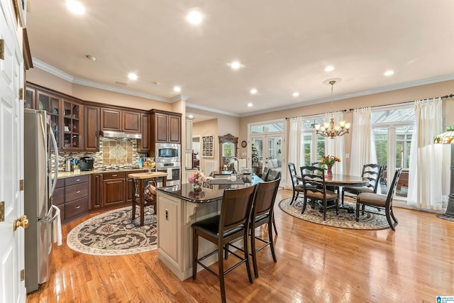 135 Weatherly Way, Pelham, AL 35124 - kitchen featuring stainless steel appliances, light wood-style flooring, a kitchen island with sink, a kitchen breakfast bar, and under cabinet range hood