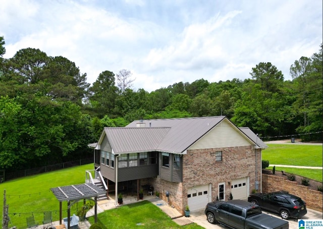 3455 Self Creek Rd, Warrior, AL 35180 - view of front of house featuring a garage, metal roof, driveway, stone siding, and a forest view