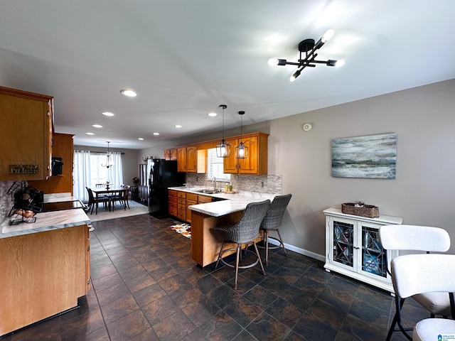 3455 Self Creek Rd, Warrior, AL 35180 - kitchen featuring a sink, a peninsula, freestanding refrigerator, recessed lighting, and brown cabinetry