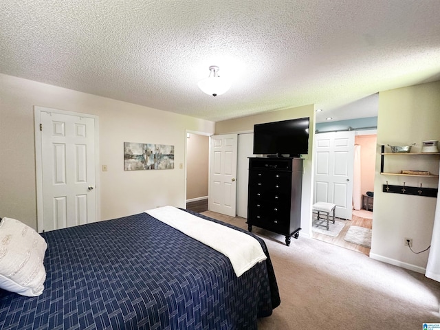 3455 Self Creek Rd, Warrior, AL 35180 - carpeted bedroom with a barn door, a closet, a textured ceiling, and baseboards