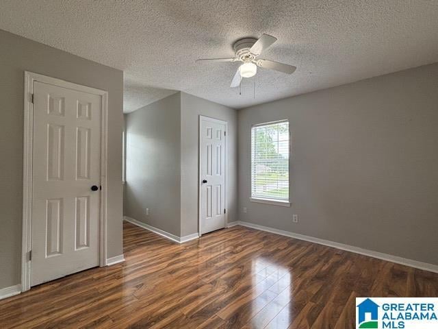 7601 Meadows Dr S, Mobile, AL 36619 - unfurnished bedroom featuring dark wood-style flooring, a textured ceiling, baseboards, and ceiling fan