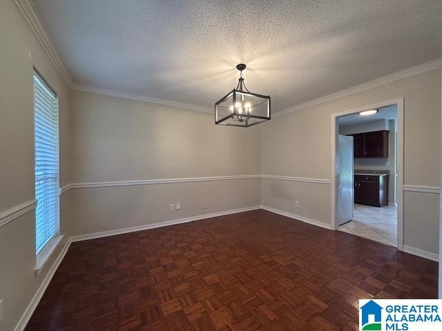 7601 Meadows Dr S, Mobile, AL 36619 - spare room featuring a chandelier, baseboards, a textured ceiling, and ornamental molding