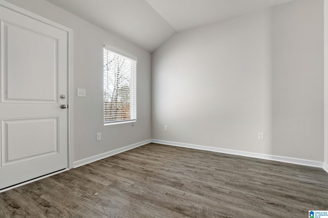 unfurnished room featuring wood finished floors, lofted ceiling, and baseboards