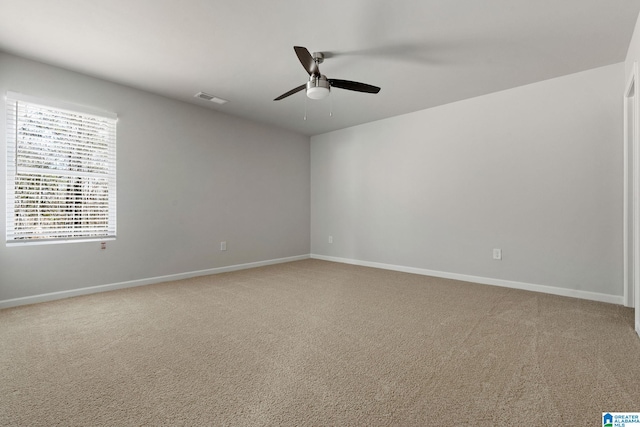 empty room with ceiling fan, light carpet, and baseboards