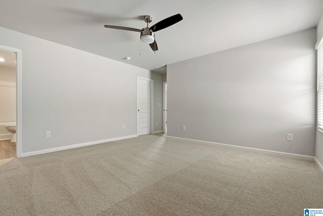 unfurnished bedroom featuring carpet flooring, connected bathroom, baseboards, and a ceiling fan