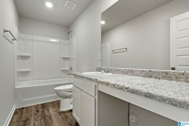 bathroom with wood finished floors, vanity, toilet, tub / shower combination, and recessed lighting