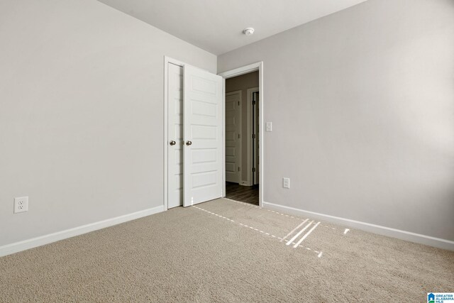 unfurnished bedroom featuring carpet flooring and baseboards