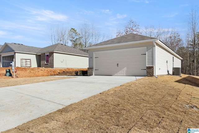 view of home's exterior with central AC, a garage, and driveway