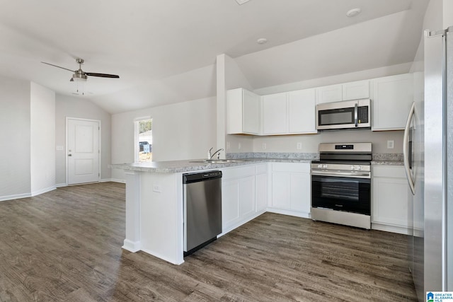 kitchen featuring stainless steel appliances, lofted ceiling, a sink, white cabinetry, and light countertops